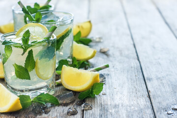 Chilled mint lemonade with mint leaves and fresh lemon. Copy space background.