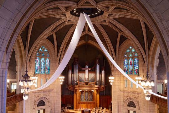 sanctuary and stained glass windows under rib vaulted ceiling of historic methodist church interior built in english gothic style architecture minneapolis minnesota 