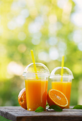 Freshly squeezed orange juice on wooden table on natural background