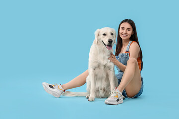 Happy woman with cute Labrador Retriever dog on light blue background. Adorable pet