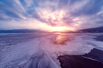 Fototapeta premium Frozen surface of Baikal lake at sunset. Russia.