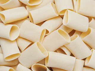 close up of dried italian paccheri tube pasta food background