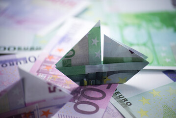 ship origami banknotes on a background of money