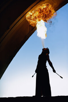 Fire artist performing extreme fire breathing in the arch