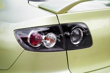 Fototapeta premium Close-up glossy tail light of car with leaf green paint.