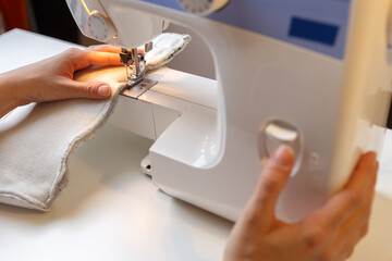 Photo of girl working on sewing machine at home
