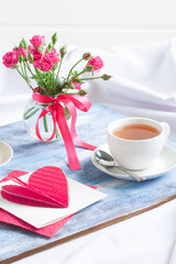 Morning Valentine's breakfast tea, gift card with hearts, flowers on blue wooden tray.