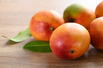 Mango fruit (Tommy Atkins) on wooden background, Tropical fruit