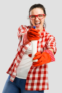 Pretty woman wearing gloves and holding a cleaning spray
