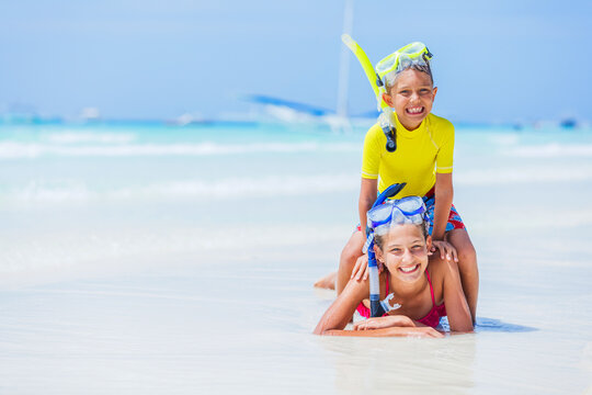 Photo of happy snorkeling girl and boy on the white beach