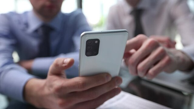 Close up of young business man using mobile smart phone