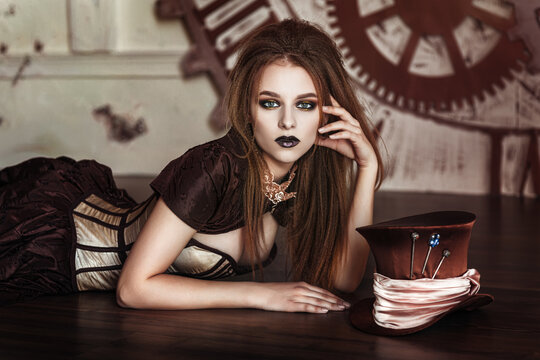 Portrait of a beautiful steampunk woman near big clock