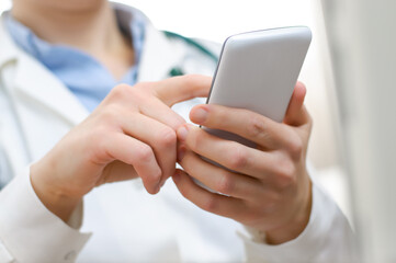 A female doctor texting on smartphone in medical office