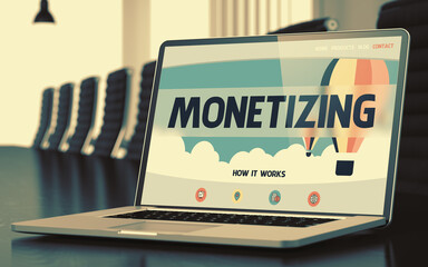 Modern Conference Room with Laptop on Foreground Showing Landing Page with Text Monetizing. Closeup View. Toned. Blurred Image. 3D Render.