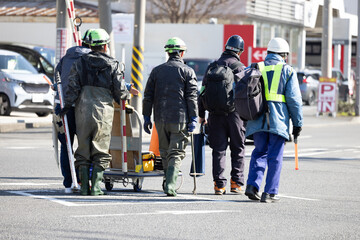 交差点での道路補修作業を終え、撤収する作業員達