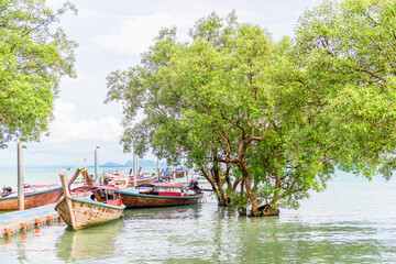 Naklejka na ściany i meble Pier with traditional Thai wooden boats, sea view