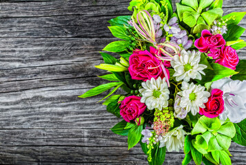vintage wedding bouquet with roses and white gerberas on an old wooden table, view from above