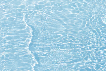 Fototapeta premium Blue water with ripples on the surface. Defocus blurred transparent blue colored clear calm water surface texture with splashes and bubbles. Water waves with shining pattern texture background.