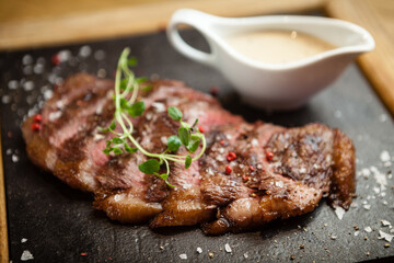 Sliced steak Picanya with sauce served on s stone board