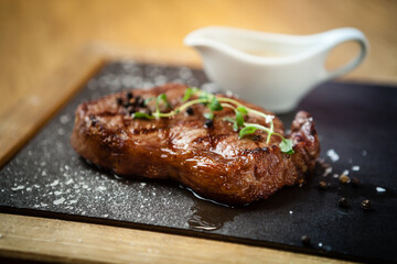 New York steak with sauce seved on a stone board