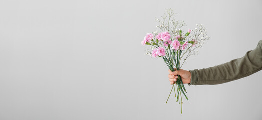 Hand holding beautiful bouquet on light background. Banner for design
