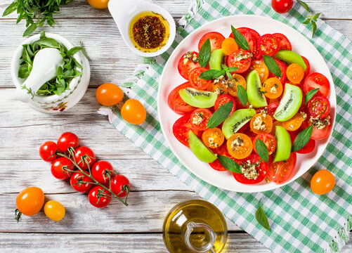 tomato, kiwifruit and mint salad with bottle of olive oil
