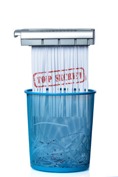 Destroy Top Secret Documents. Shredder documents with printed images concept thrown in the trash. White and blue basket.