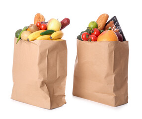 Paper bags with vegetables, fruits and sausages on white background
