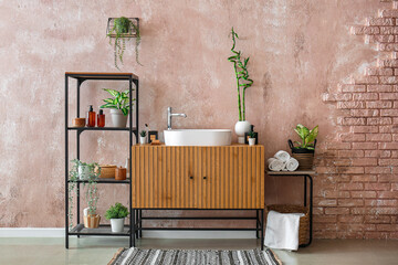 Interior of stylish bathroom with sink, drawers and shelving unit