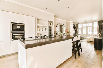 a modern kitchen with white cabinets and black counter tops on the island in this room is very spacious, but it's not