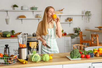 Young woman with orange in kitchen