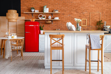 Interior of kitchen with red fridge, counters, shelves and chairs