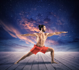 Fototapeta na wymiar Man in a yoga position under the sky with stars