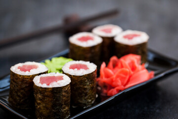Fresh delicious tuna maki sushi rolls on dark background, japanese food