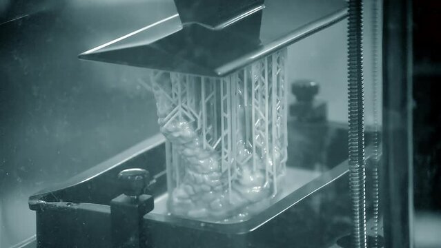Working of photopolymer sla 3D printer. Platform with building object lowered into liquid photopolymer resins and hardened under ultraviolet laser. Progressive additive technology. 3D printer printing