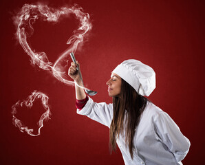 Woman chef smelling the aroma from the ladle