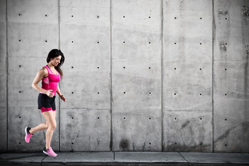 Athletic woman runner in sportswear on the asphalt of a road