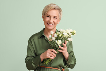 Mature woman with beautiful roses on green background