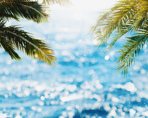 Tropical beach with coconut tree with sunray reflected on the bright sea