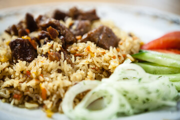Uzbek pilaf with beef on a wooden background