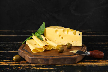 Board with tasty Swiss cheese on table