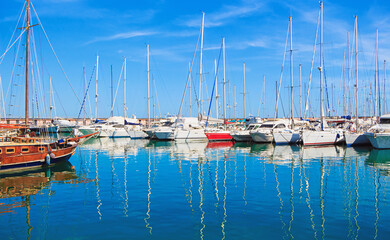 Fototapeta na wymiar Photo of incredible beauty Harbor Yacht Club with glazed clear sea and blue clouds. Italy. Nettuno.