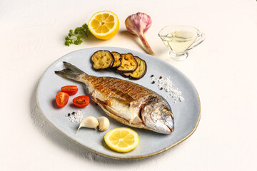Plate with tasty grilled dorado fish on white background