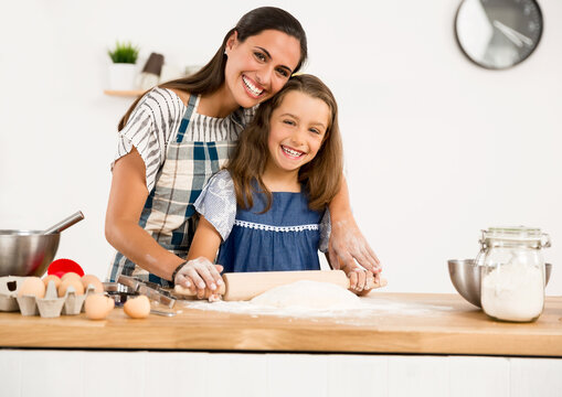 Shot of a mother and daughter having fun in the kitchen and learning to make a cake