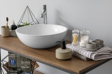 Table with sink bowl, soap dispenser and bath accessories in bathroom