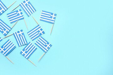 Many paper flags of Greece on blue background
