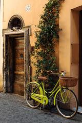 Fototapeta na wymiar Old street in Trastevere in Rome, Italy, stylish bycice parked in front of shop entrance