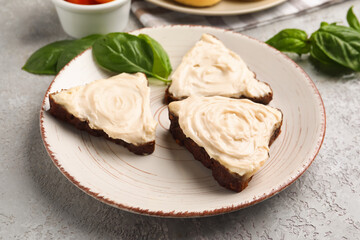 Plate of tasty sandwiches with cream cheese on grey background