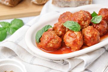 Plate of tasty meat balls with tomato sauce and basil, closeup