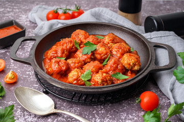 Frying pan of tasty meat balls with tomato sauce and parsley on grey background - obrazy, fototapety, plakaty